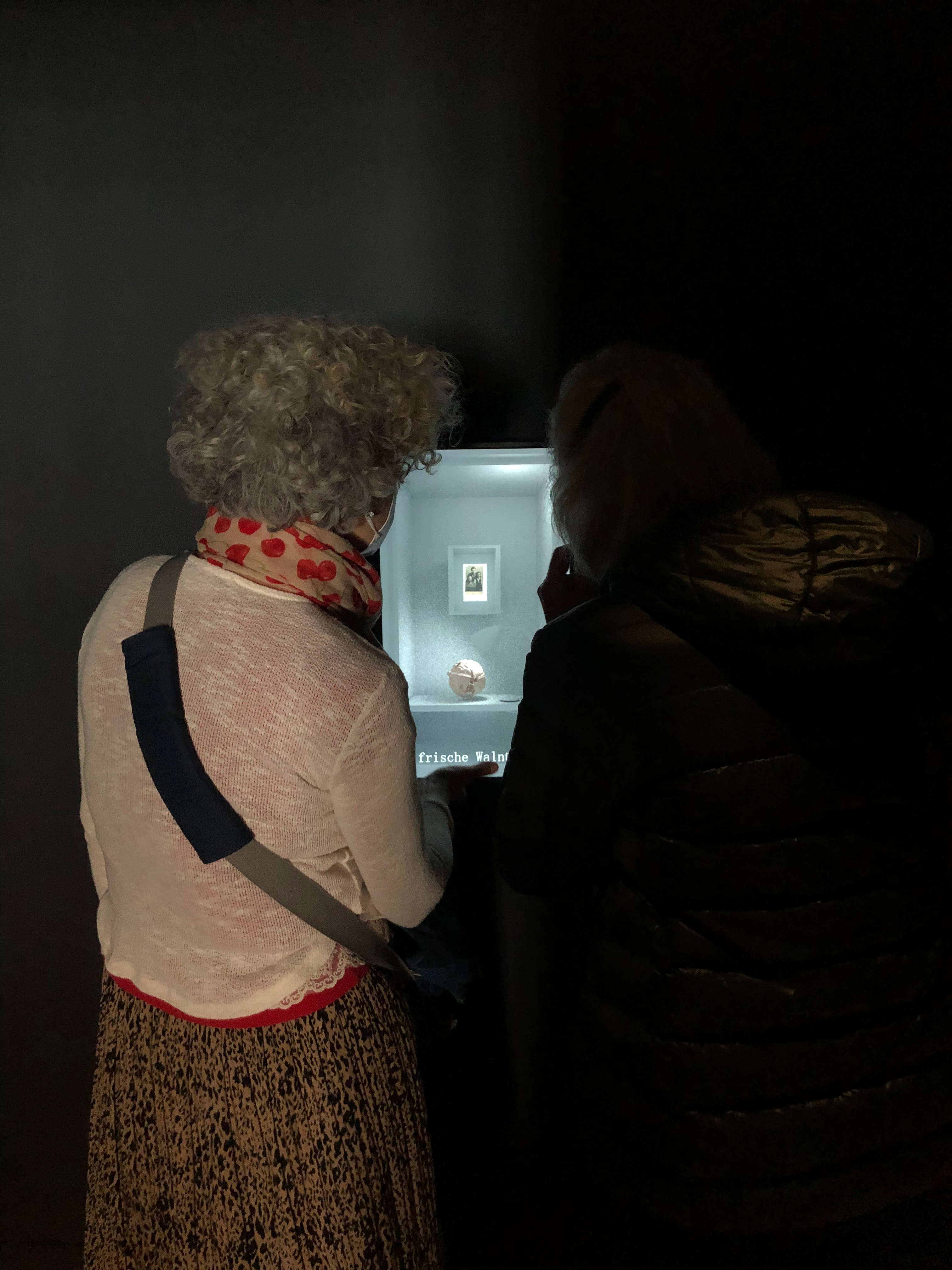 two visitors watch a video on a vertical screen